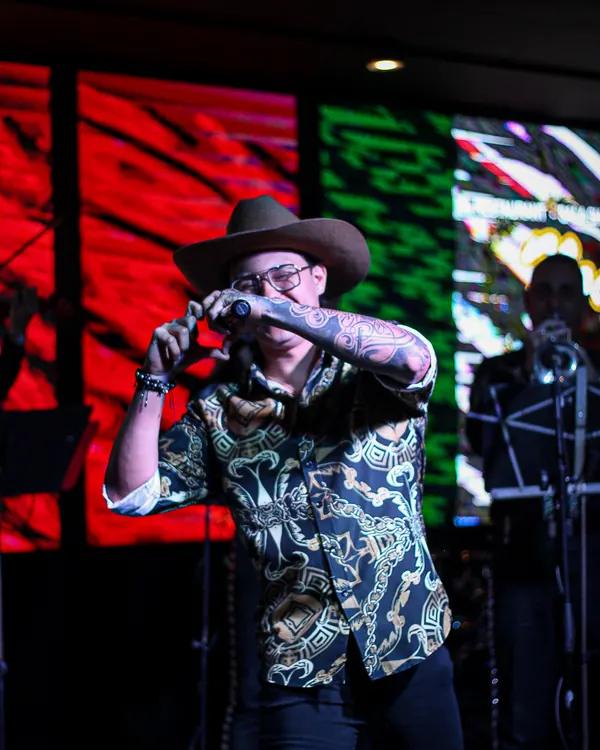 Ricardo en tarima frente a una pantalla con los colores de México